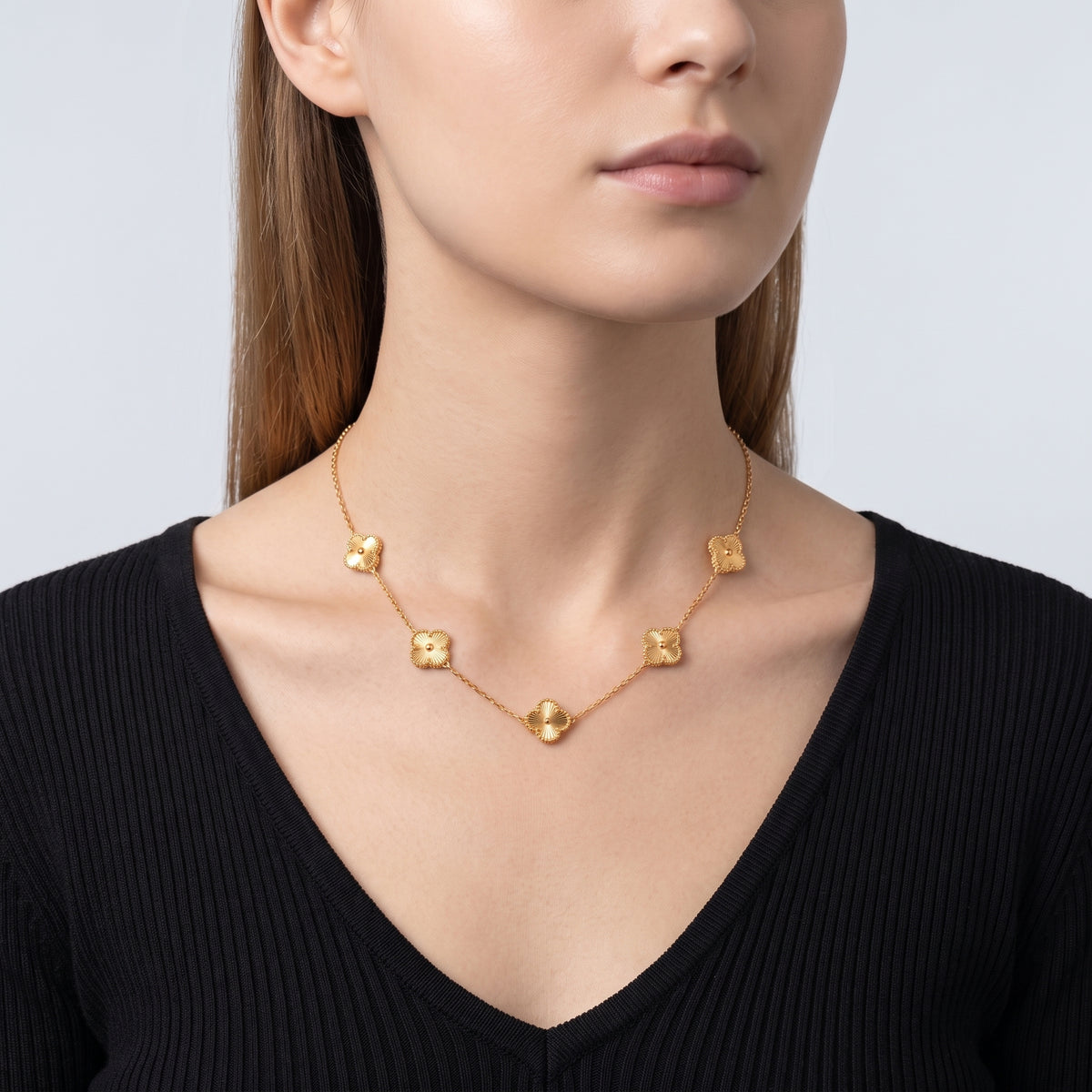 Shoulders and neckline of a woman wearing the Adèle Gold Necklace