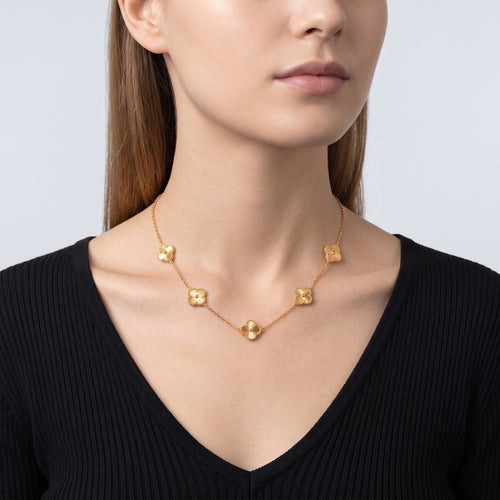 Shoulders and neckline of a woman wearing the Adèle Gold Necklace