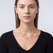Portrait of a woman wearing the Adèle Gold Necklace
