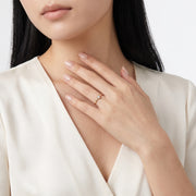 Hand resting at the collarbone wearing Aimée gold heart ring
