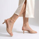 Woman mid-step through a skirt slit wearing the Amara Beaded Glow Anklet