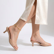 Woman mid-step through a skirt slit wearing the Amara Beaded Glow Anklet
