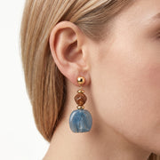 Close-up of the Lelice Amara Blue Marbled Acrylic Statement Drop Earrings in gold on the ear