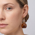 Model wearing the Lelice Amara Brown Marbled Acrylic Statement Drop Earrings in gold, one-eye face close-up