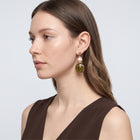 Model wearing the Lelice Amara Green Marbled Acrylic Statement Drop Earrings in gold, side profile portrait