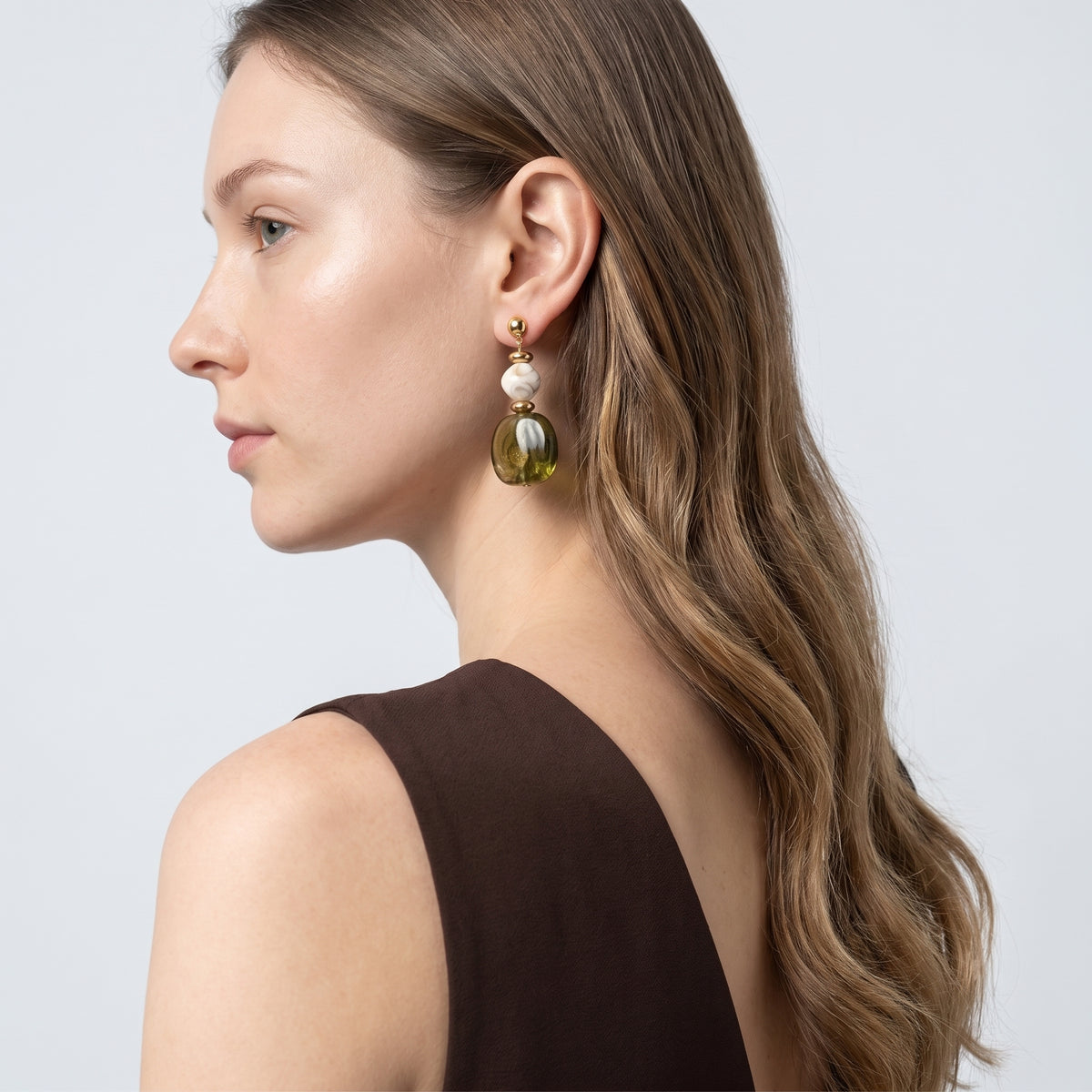 Model wearing the Lelice Amara Green Marbled Acrylic Statement Drop Earrings in gold, three-quarter back view