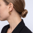 Model wearing the Lelice Amber Gold Earrings in gold, low bun, ear and neck