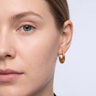Model wearing the Lelice Amber Gold Earrings in gold, one-eye face close-up