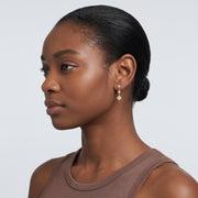 Model wearing the Lelice Ambre Glow Earrings in gold, slicked-back profile