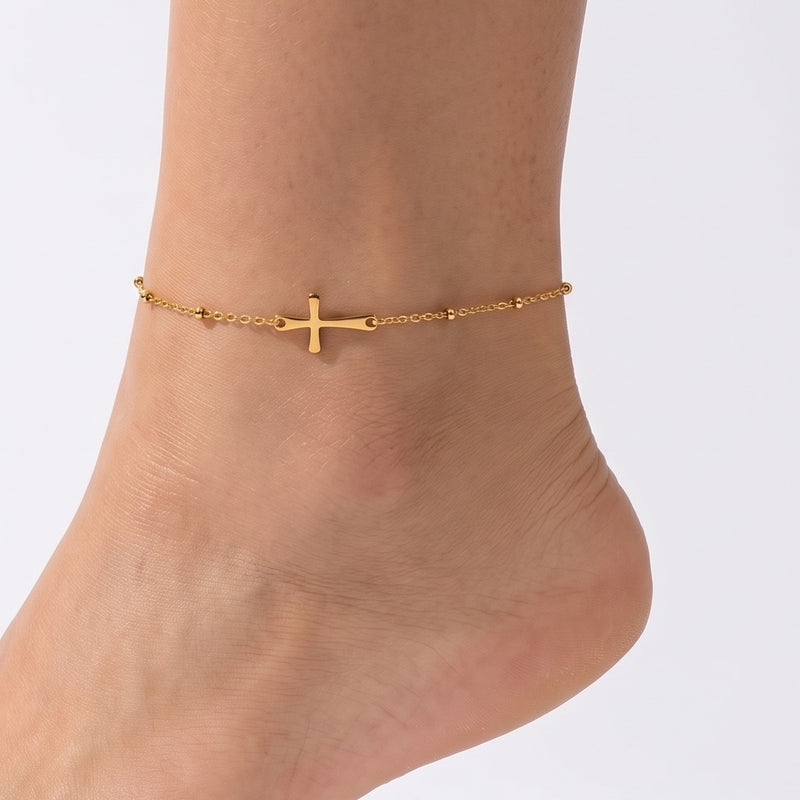 Close-up of the Lelice Amira Gold Cross Anklet on a woman's ankle