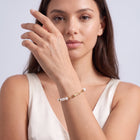 Model wearing the Lelice Ana Pearl Bracelet in gold, hand in front of the face