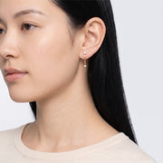 Model wearing the Lelice Andromeda Drop Earrings in gold, turned toward the light