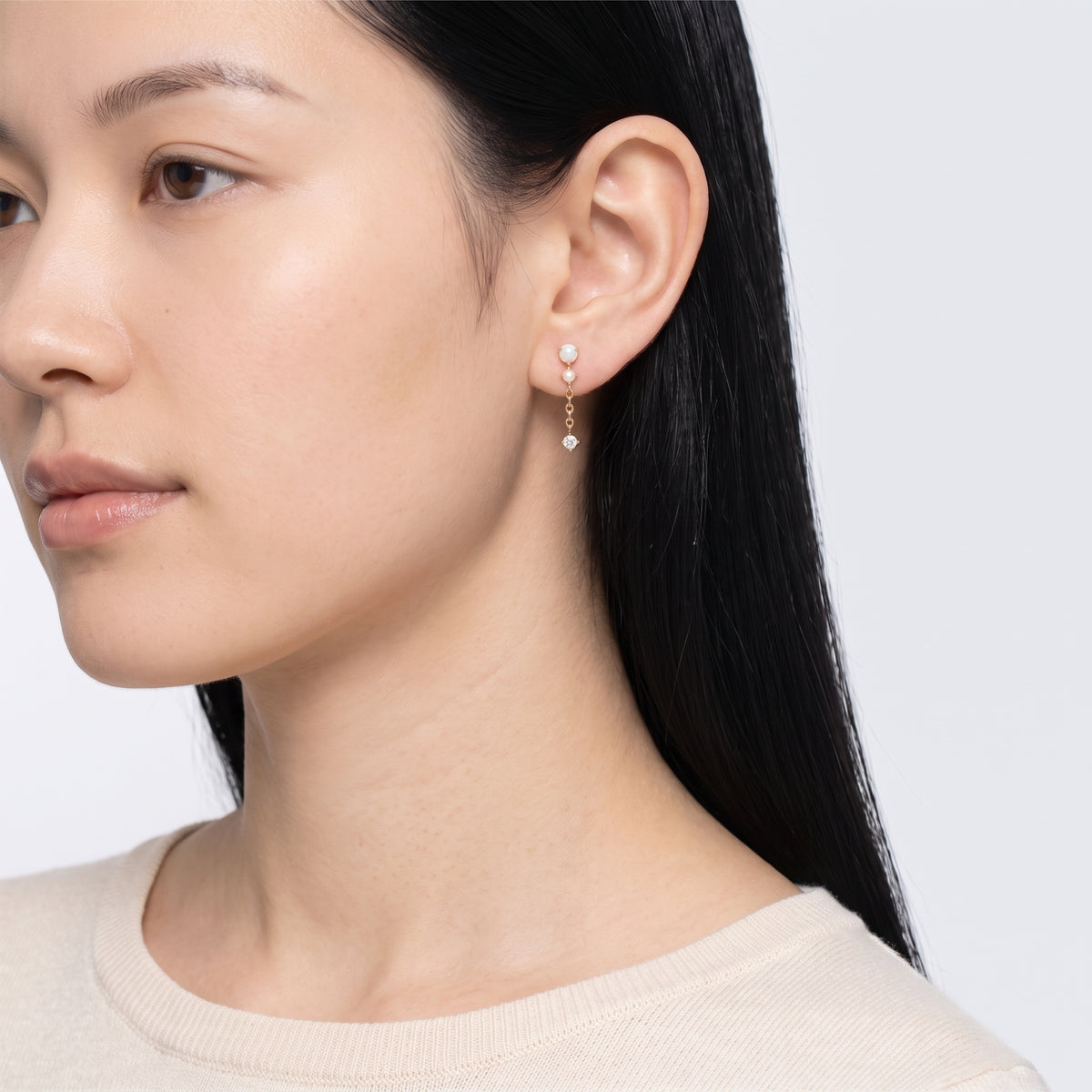 Model wearing the Lelice Andromeda Drop Earrings in gold, turned toward the light