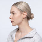 Model wearing the Lelice Astra Sunburst Huggies in gold, slicked-back profile