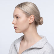 Model wearing the Lelice Astra Sunburst Huggies in gold, slicked-back profile