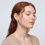 Model wearing the Lelice Ava Curved Hoops in gold, serene chin lift