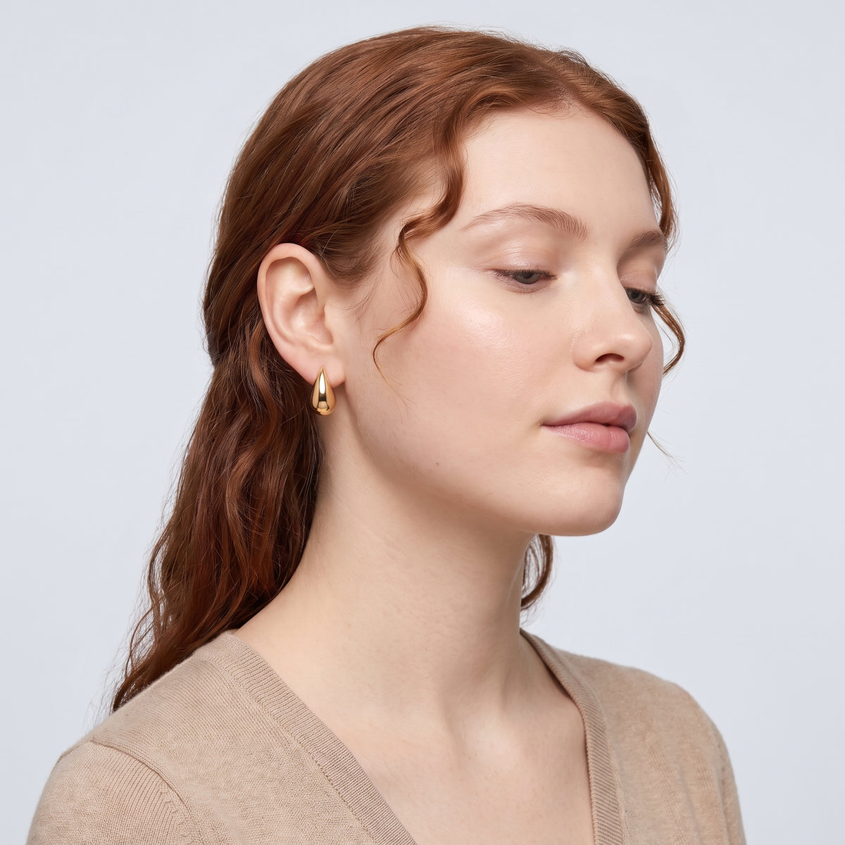 Model wearing the Lelice Ava Curved Hoops in gold, serene chin lift