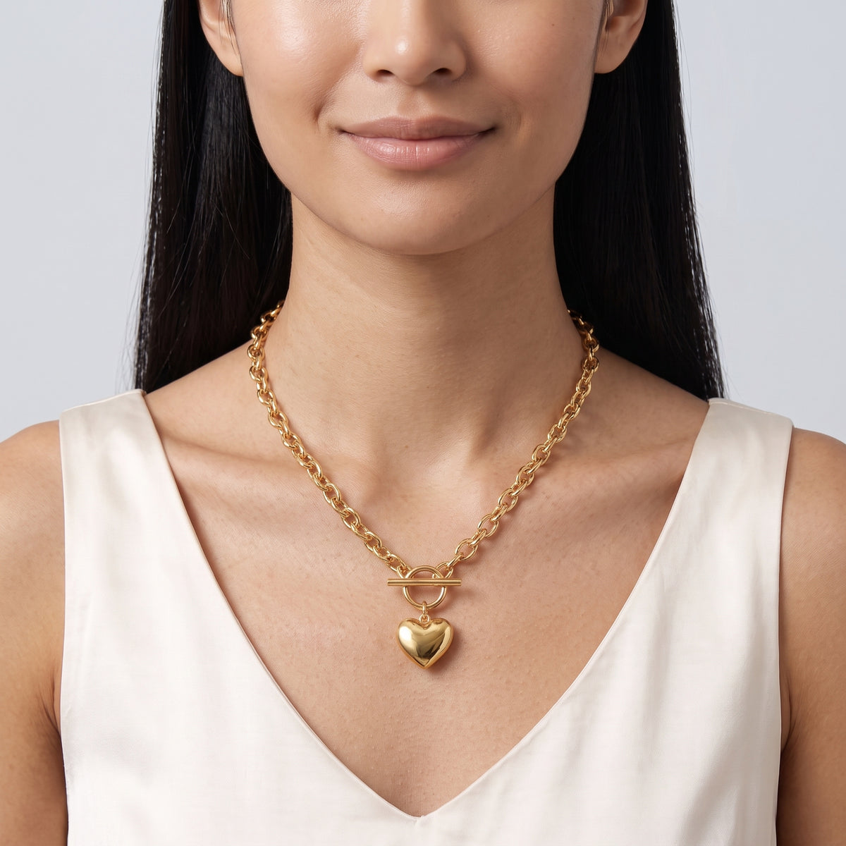 Woman with head tilted down wearing the Bea Chunky Heart Necklace