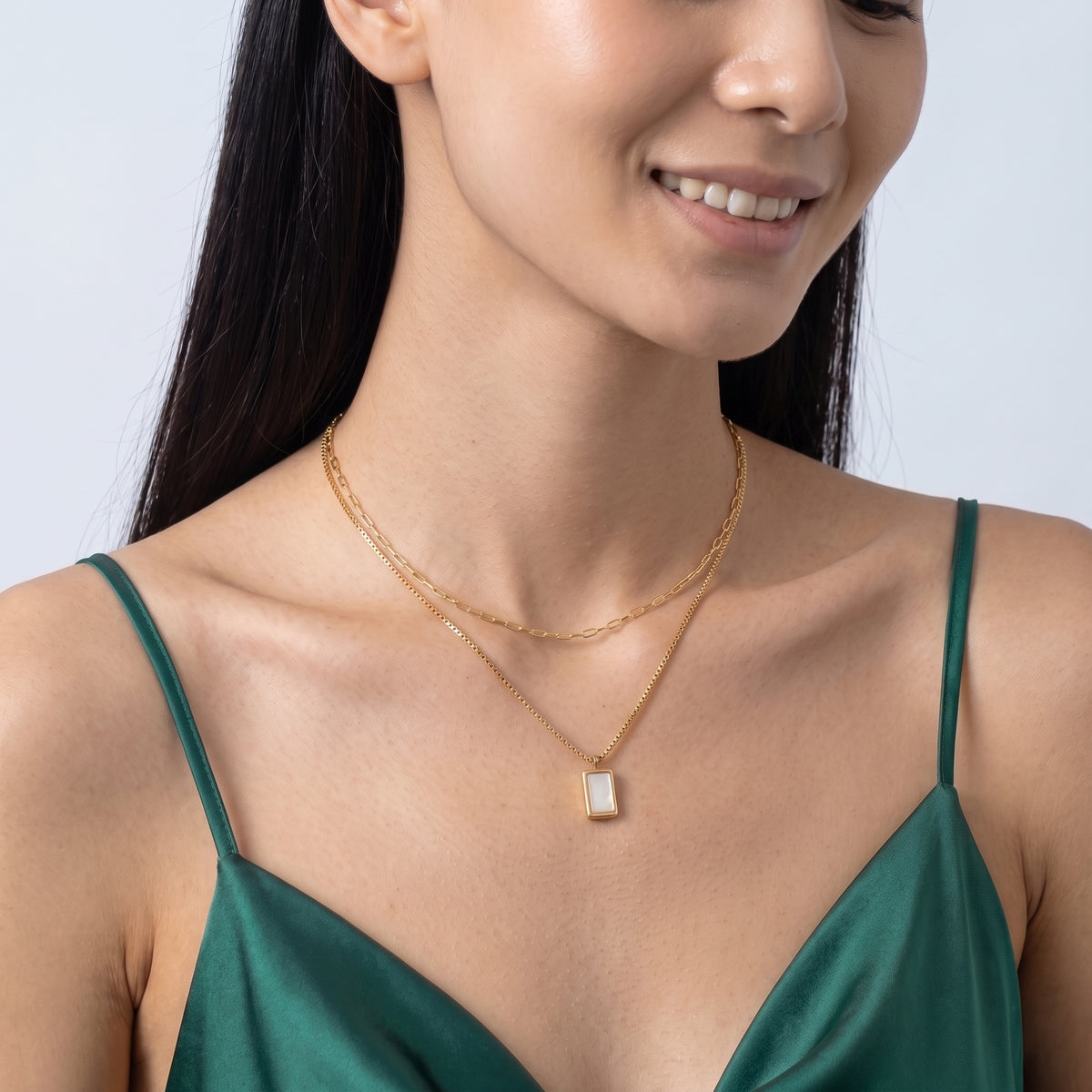 Woman with head tilted down wearing the Bianca Layered Necklace