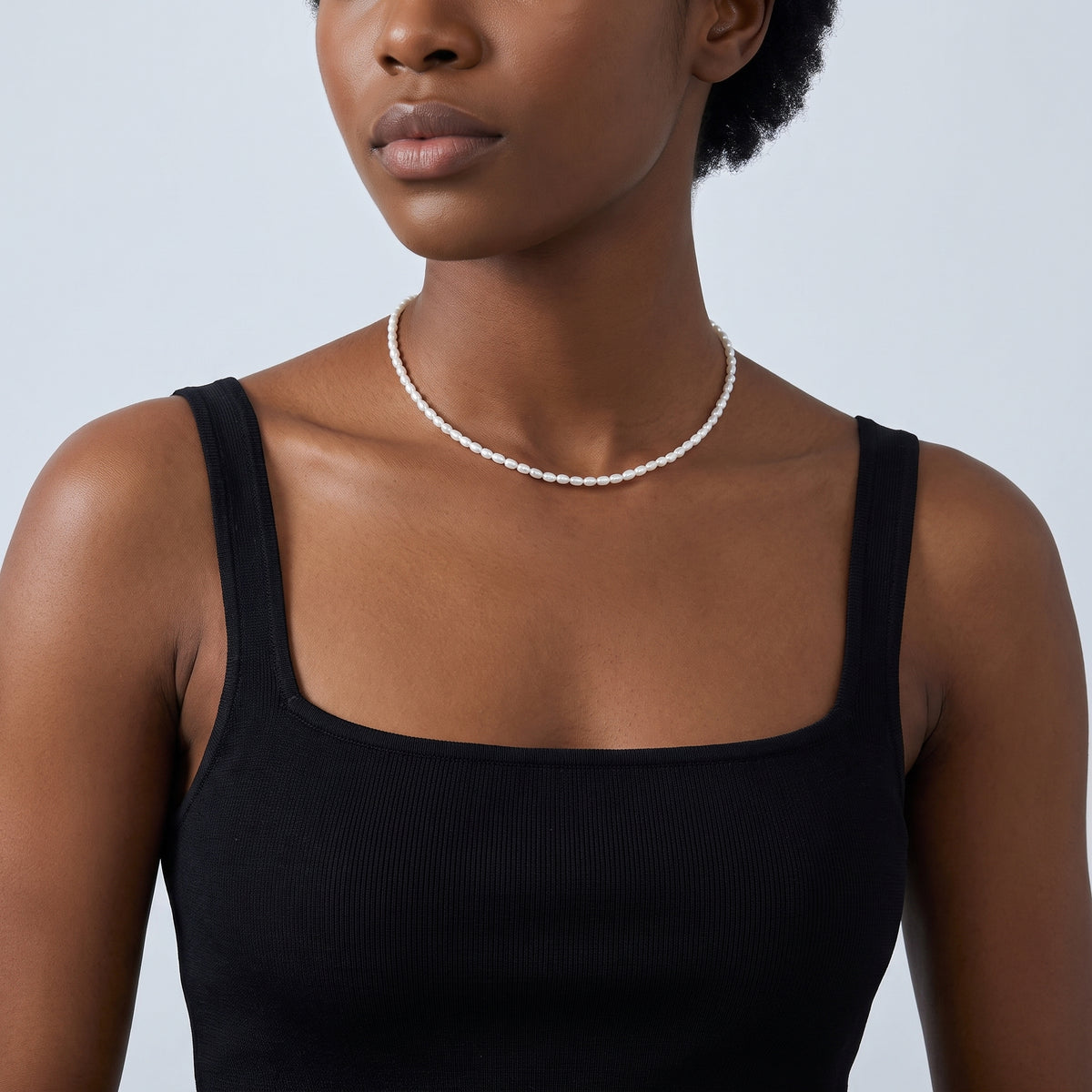 Shoulders and neckline of a woman wearing the Camille Pearl Choker