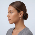 Model wearing the Lelice Céleste Sparkle Hoops in gold, slicked-back profile