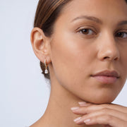 Model wearing the Lelice Céleste Sparkle Hoops in gold, hand at the chin