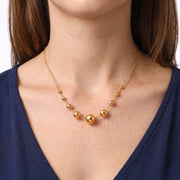 Close-up of the Lelice Celeste Sphere Necklace in gold at the collarbone