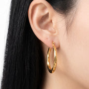 Close-up of the Lelice Claire Polished Hoops in gold on the ear