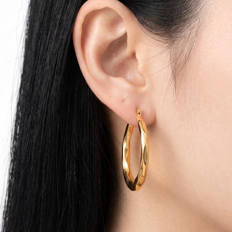Close-up of the Lelice Claire Polished Hoops in gold on the ear