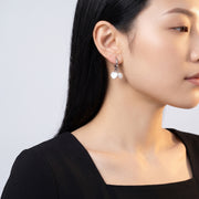 Model wearing the Lelice Cleo Pearl Silver Hoops, turned toward the light