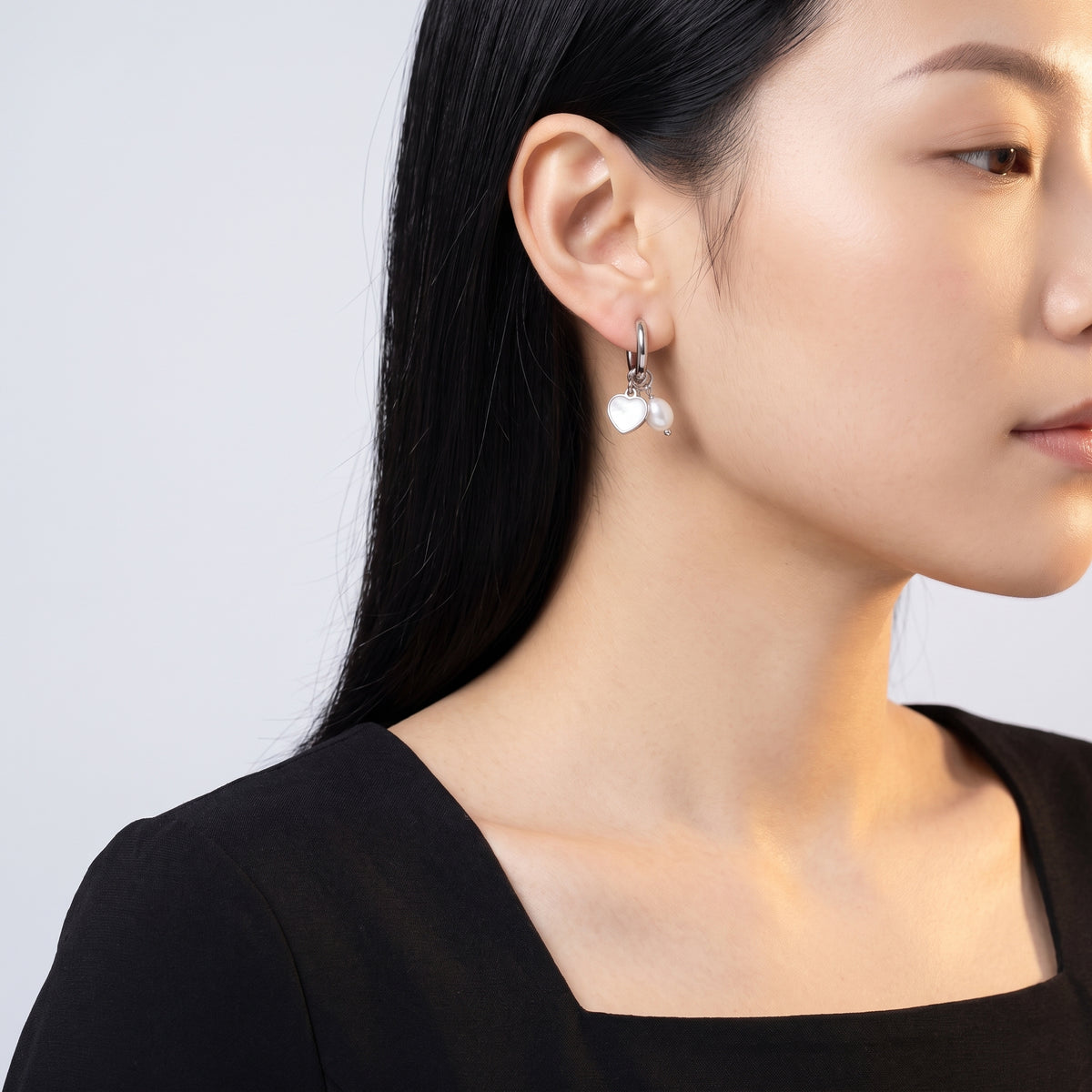 Model wearing the Lelice Cleo Pearl Silver Hoops, turned toward the light
