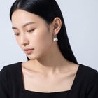Model wearing the Lelice Cleo Pearl Silver Hoops, downcast beauty portrait