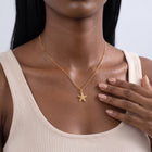 Hand at the collar of a woman wearing the Coastal Tide Necklace