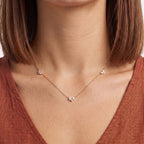 Close-up of the Lelice Constance Crystal Station Necklace in gold at the collarbone