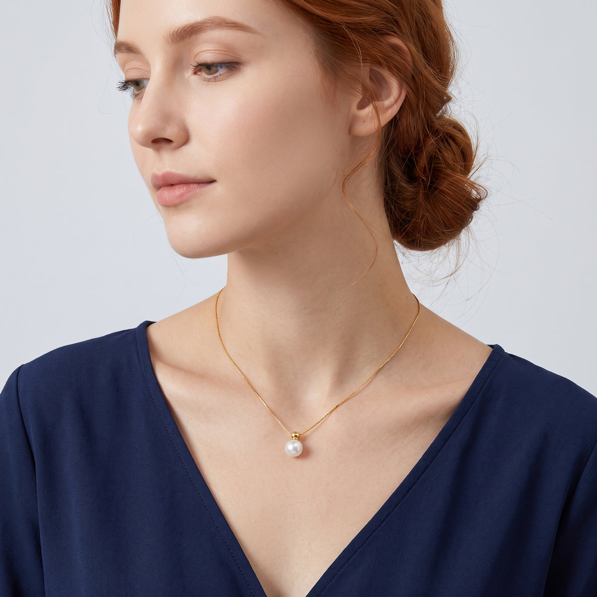 Neckline profile with hair up, wearing the Cora Pearl Drop Necklace