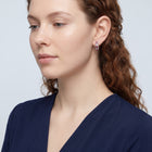 Model wearing the Lelice Crimson Ruby Hoops in silver, serene chin lift