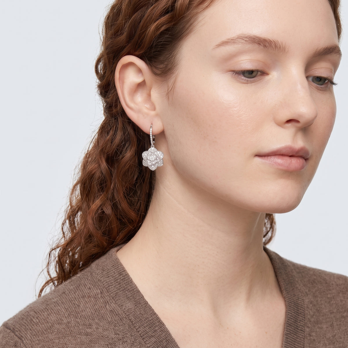 Model wearing the Lelice Crystal Rosette Silver Earrings, serene chin lift