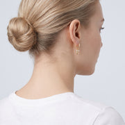 Model wearing the Lelice Dainty Bow Gold Hoops, low bun, ear and neck