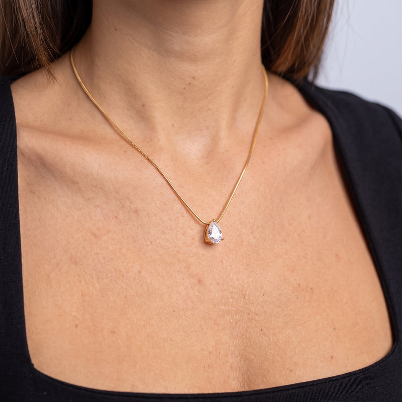 Close-up of the Dainty Pear Drop Gold Necklace resting on the skin