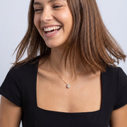 Laughing woman wearing the Dainty Pear Drop Gold Necklace