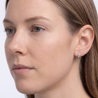 Model wearing the Lelice Demi Silver Hoops, three-quarter face close-up
