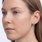 Model wearing the Lelice Demi Silver Hoops, three-quarter face close-up