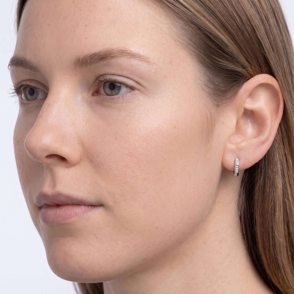 Model wearing the Lelice Demi Silver Hoops, three-quarter face close-up