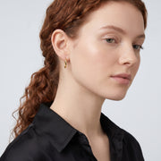Model wearing the Lelice Diane Hoop Earrings in gold, serene chin lift