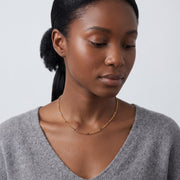 Woman looking down at the Eden Bead Necklace