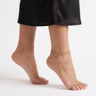 Bare foot on tiptoe wearing the Elara Double Strand Anklet