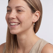 Model wearing the Lelice Elena Protection Earrings in gold, candid laugh