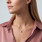 Woman in soft side light wearing the Eleni Petite Necklace