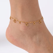 Close-up of the Lelice Elina Clover Frame Anklet in gold on a woman's ankle