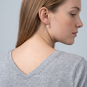 Model wearing the Lelice Elisa Crystal Earrings in gold, over-the-shoulder glance